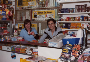 A woman and man behind a convenience store counter