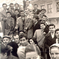 Dozens of people standing in a street.