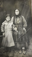 Older woman holding hand of young woman in coat.