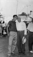 Older man with arm around taller, younger man.