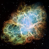 The Crab Nebula in a photo taken by the Hubble Telescope, with the bright green, red and blue colours of the nebula visible amongst the stars.