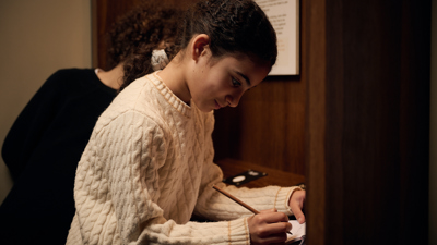 Kids doing a dictation test interactive exhibit in Leaving Home exhibition at the Immigration Museum.