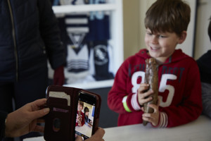 A child has a picture taken while holding an item on display