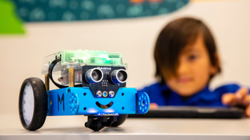 Primary School student using an iPad to program a robotic vehicle, in the STEM Learning LAB at Scienceworks