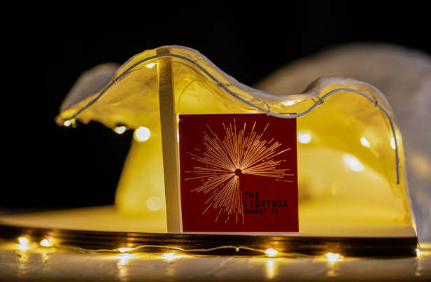An architectural model of the LightBox Community Stage Space, which is illuminated and has signage that reads ‘The Lightbox August 26.’