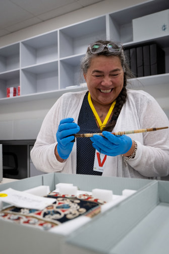 a smiling woman holding a smoking pipe