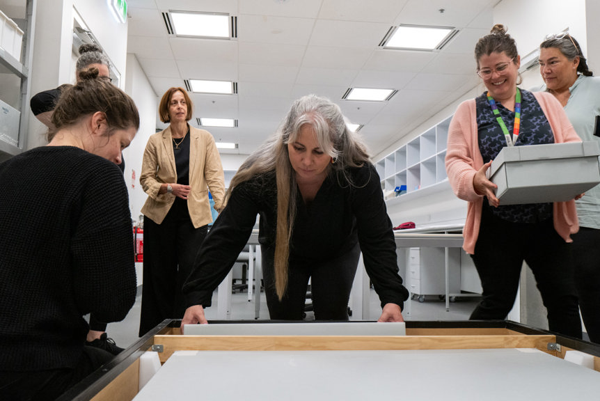a group of women packing boxes in to a crate