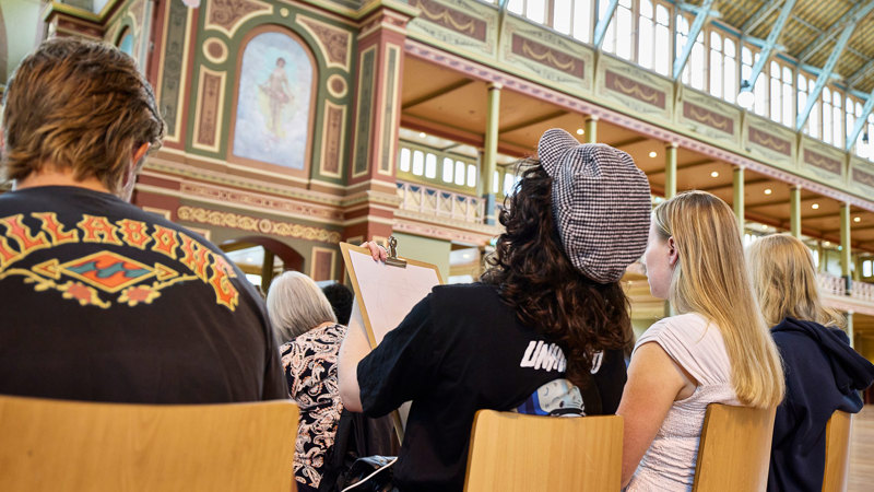 A group of art students drawing the ornate details of the Royal Exhibition Building ceiling.