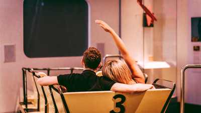 a couple sit with their arms around each other at Melbourne Museum