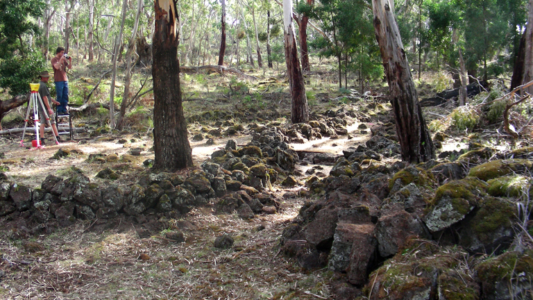 Man photographing rock formations in bushland
