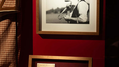 A black and white photo of Phar Lap and trainer in a red display case at Melbourne Museum.