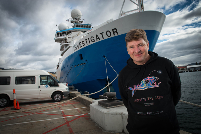 Museums Victoria scientist Tim O'Hara stands in front of the Marine National Facility research vessel <i>Investigator</i>.