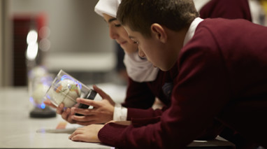 Girl and boy looking at a small globe