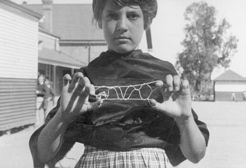 Girl Playing 'Bridge' or 'French Lace' String Game, Dorothy Howard Tour, Australia, 1954-1955