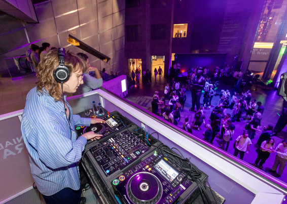 D. Tyrone in a white pin-stripe blue shirt djing.