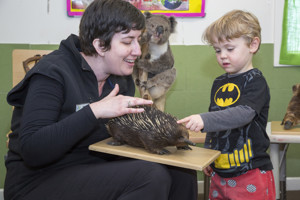 Woman and a boy looking at a stuffed echidna