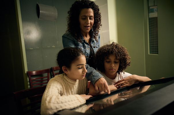 A mother and children use an interactive display in Leaving Home exhibition at thew Immigration Museum.