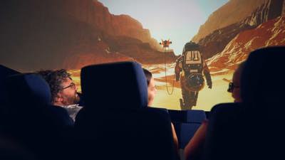 A trio watch a film of an astronaut on the planetarium screen at Scienceworks.