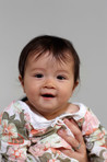 A one year old baby wearing a floral top
