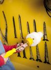 A child using a Phillips head screwdriver to find a screw which fits