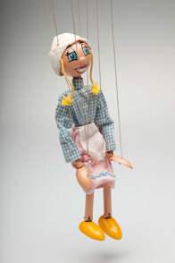 Marionette depicting a girl dressed in a blue and white plaid blouse, pink skirt, white apron and a peasant hat.