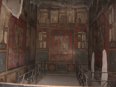An empty dining room with frescos on all three walls 
