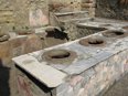 A masonry counter with a tiled top with round containers depressed into it