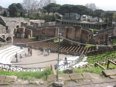 Tourists exploring the horseshoe-shaped Pompeii Grand Theatre 