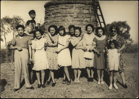 Gung family standing in front of stone wall and ladder. It was taken at Lake Mountain, circa 1930s-40s.  