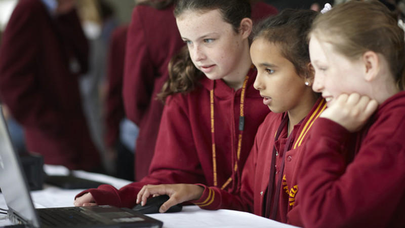 3 students sitting around a computer