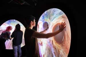 Visitors stretching flexible video screens