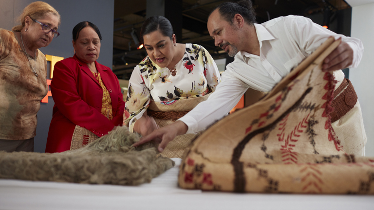 Sione Napi Francis showing Princess Saloe items from the Museum’s collection, including a Rotuman Fine mat, during her visit to Melbourne Museum, 2018.