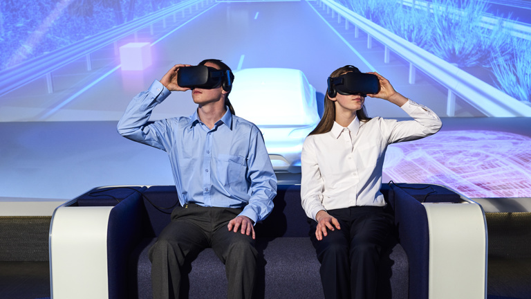 Two students using virtual reality googles to experience a road trip from the past to the future of travel in Victoria.