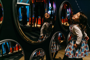 Child interacting with mirrors display in the Ground Up exhibition