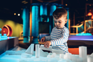 Boy playing with clear building blocks in the Ground Up exhibition 