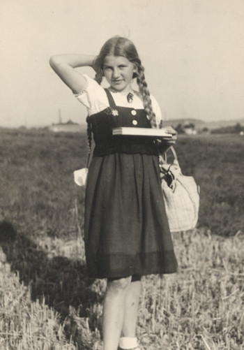 Black and white image of a girl standing in a field