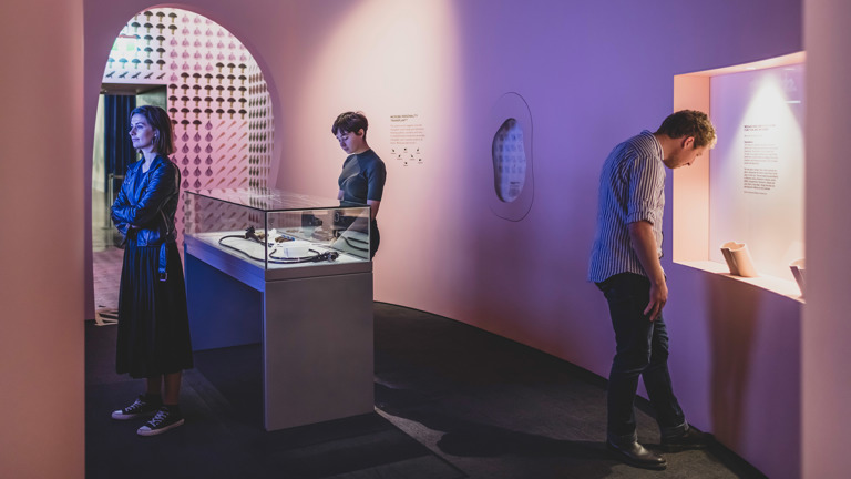 Three people looking an exhibition