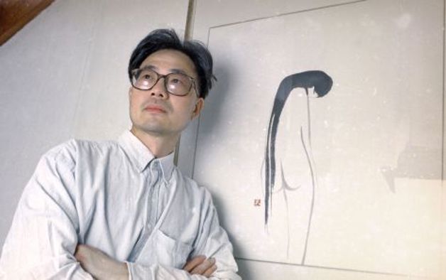 Man standing next to a painting