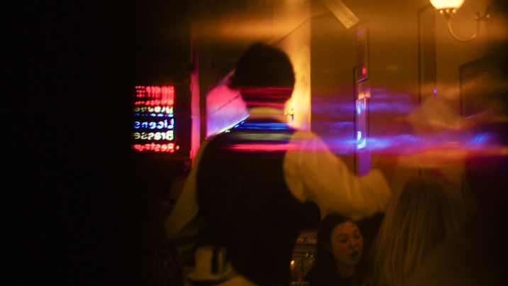 Lights dance across the blurred image of a waiter moving quickly to serve people in a Melbourne resturaunt.