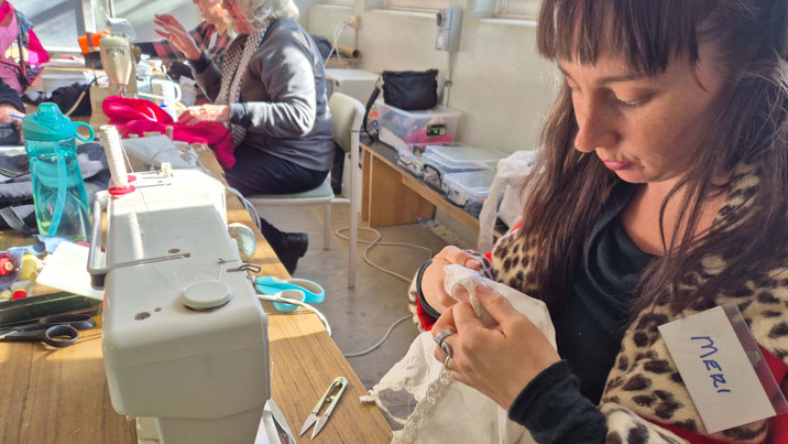 A person at a sewing machine fixing a garment