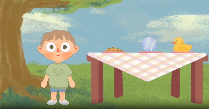 Animation still showing a small child in green T-shirt and shorts, standing in a park beside a picnic table with a gingham cloth, topped with plate of biscuits, ball, and rubber duck.