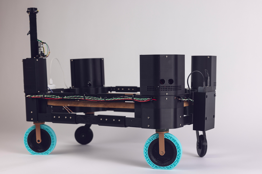 Black, wheeled robotic platform with exposed wiring and electronic components.