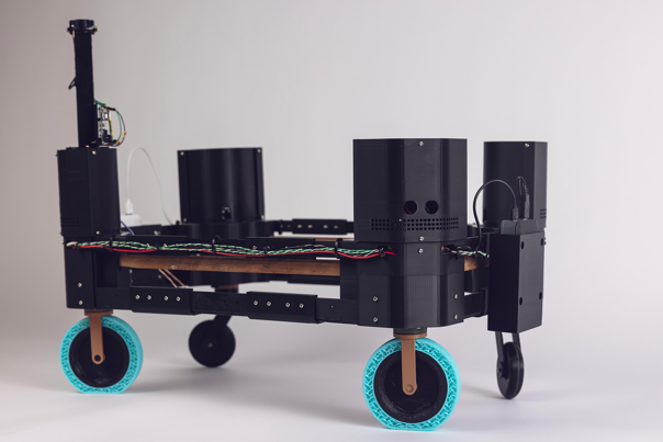 Black, wheeled robotic platform with exposed wiring and electronic components.