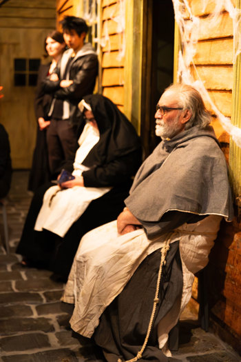 A man dressed as a member of the clergy outside little Landsdale exhibition during Halloween at the Museum.