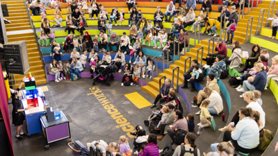 A presenter is showing differently coloured blocks to a crowd in the Scienceworks amphitheatre.  