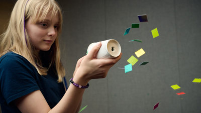 A young adult fires confetti from an air cannon they have made during a Science Studio workshop at Scienceworks.