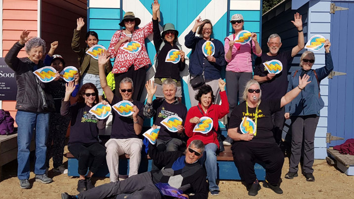 A group of people at a beach excited about renewable energgy