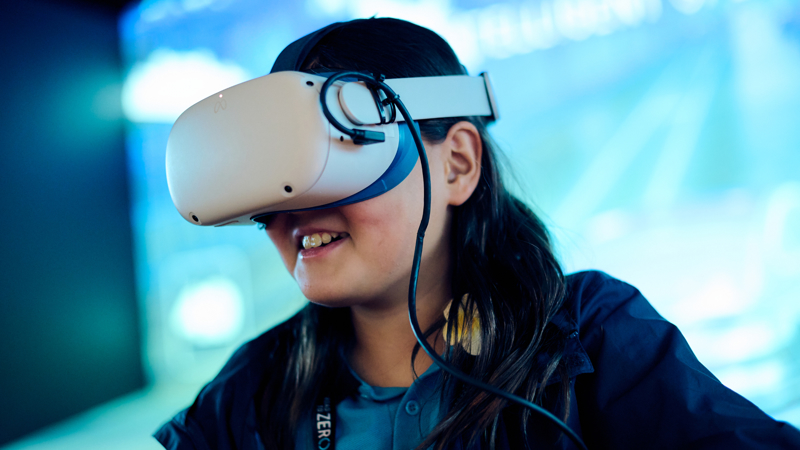 A student wearing a virtual reality headset in the Road to Zero Experience Space 