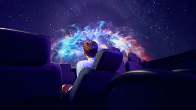 A secondary school student views a nebula on the dome of the Melbourne Planetarium