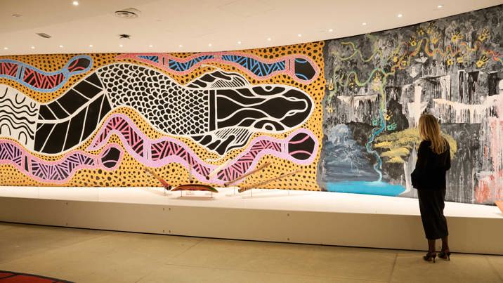 A person viewing the large mural artworks in Birrarung Gallery